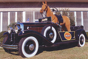 The Moxie horsemobile. An antique car with a horse statue in it. The steering wheel is in the pommel. The pedals are each side of the body.